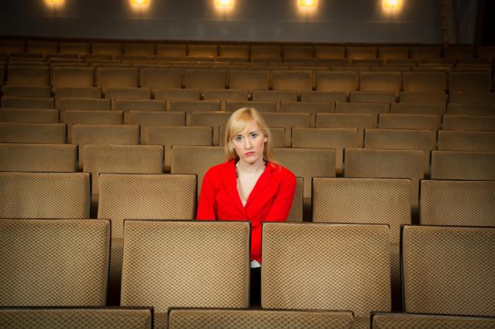 A woman alone in a theater.