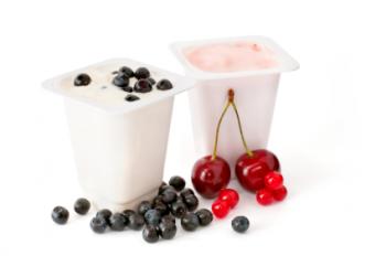 Two portions of yogurt with assorted berries.