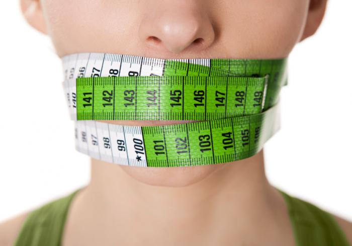 A woman with a tape measure around her mouth