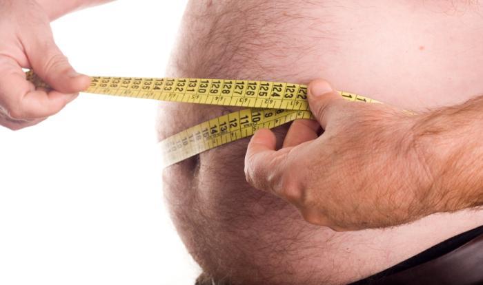 Obese man measuring waist