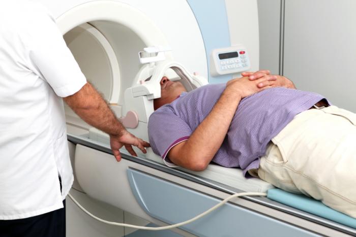 A man is about to enter an MRI machine.