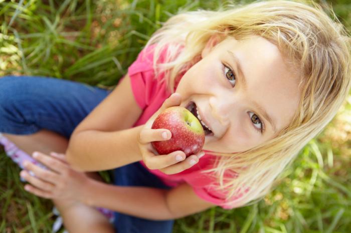 [A little girl eating an apple]