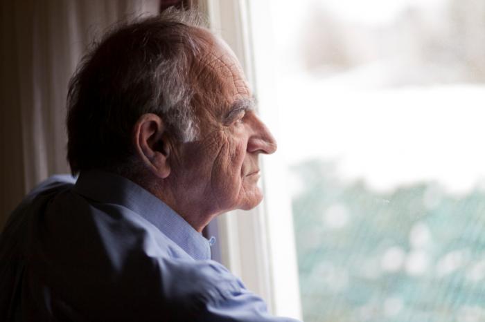 An older man looking out of the window.