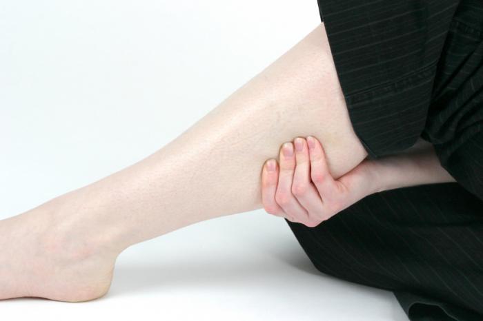 woman clutching painful lower leg