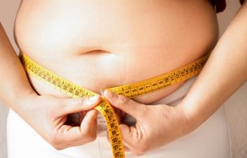 Obese teen measuring waist