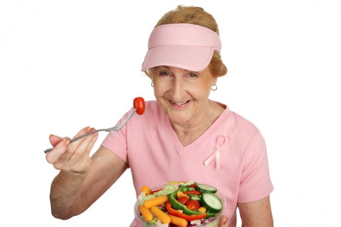 An older woman eating vegetables.