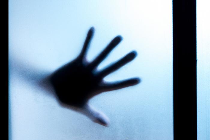 [A hand against glass]