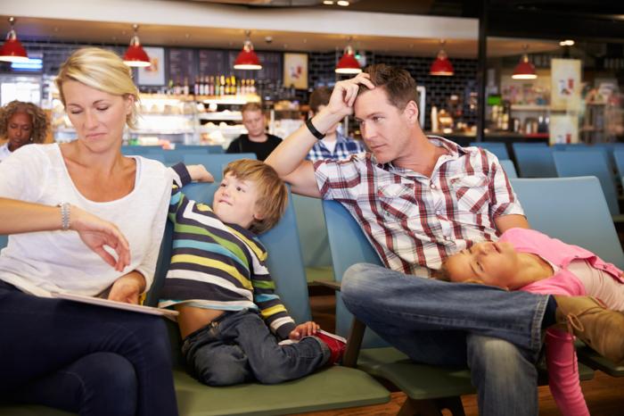[Family waiting for a delayed flight in a departure lounge]