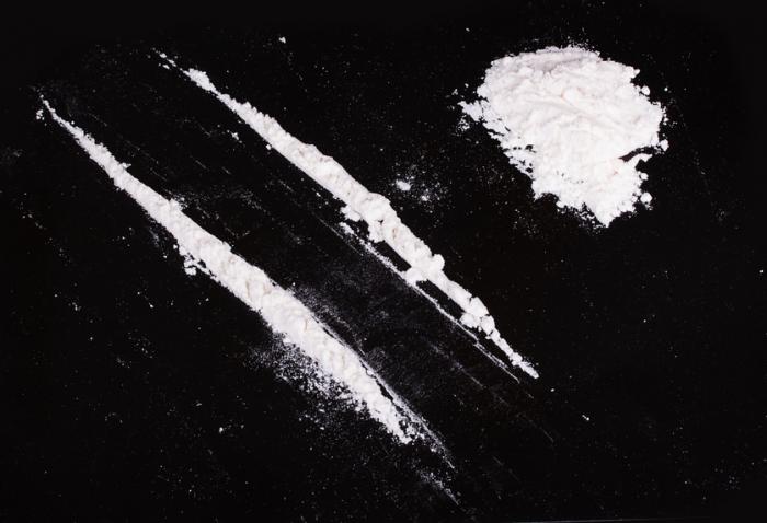 [Lines of cocaine on a black surface]