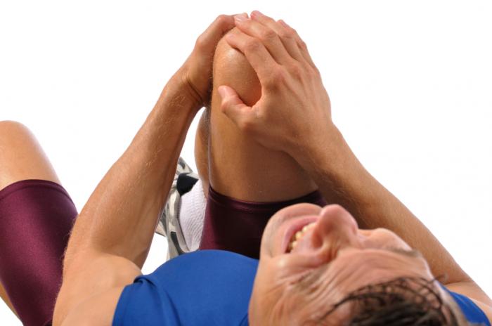 Man clutching painful knee