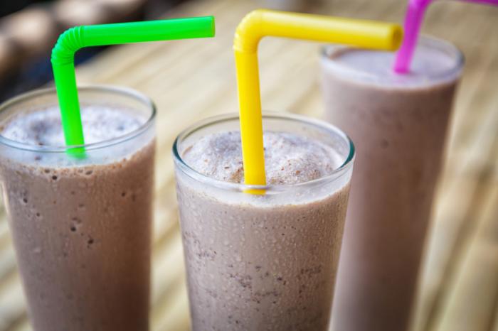 three protein shakes in glasses with straws